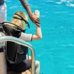 Young woman diver preparing for scuba diving